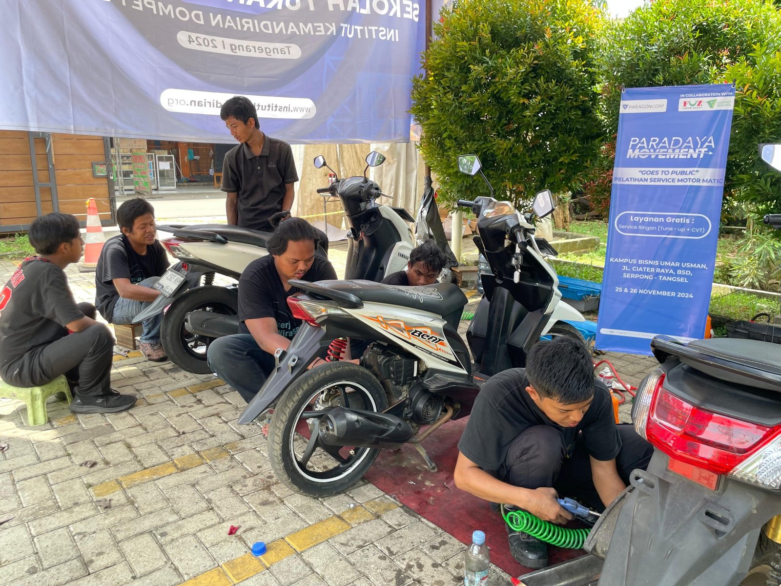 Dibimbing oleh Instruktur, peserta pelatihan Paradaya Movement melakukan praktek langsung layanan service motor gratis dalam ‘Goes to Public’ di wilayah Serpong, Tangerang Selatan, pada Selasa, (26/11/2024).