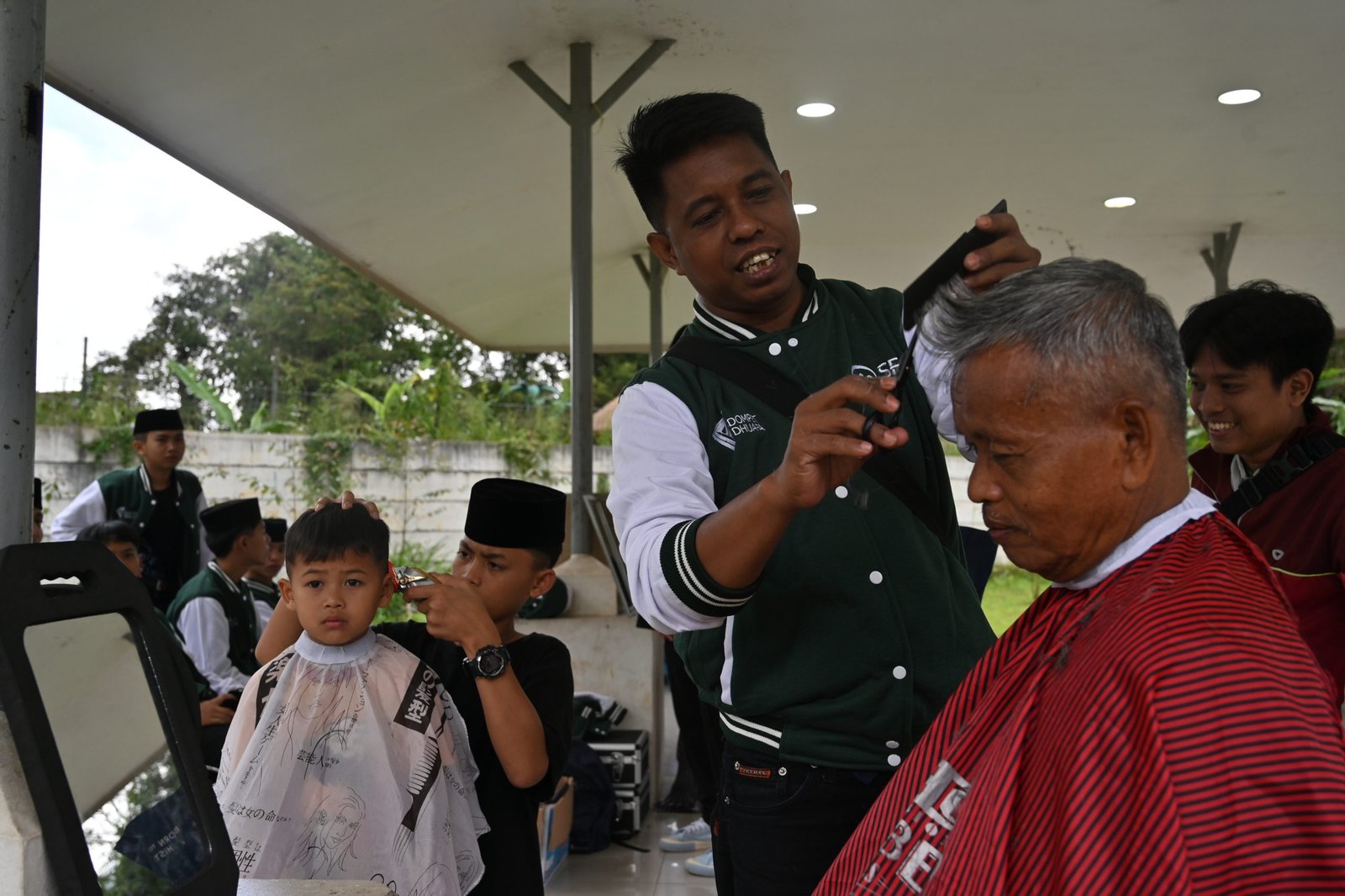 Layanan pangkas rambut oleh peserta pelatihan kepada masyarakat Cisarua, Bogor pada acara Goes to Public. Bogor, Ahad (19/01/2025).