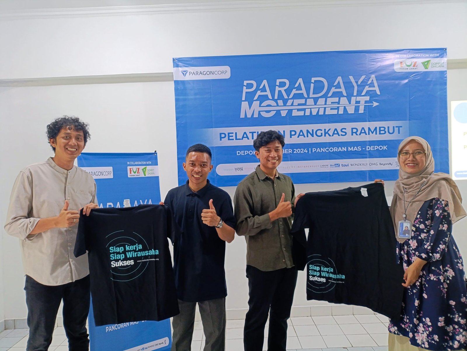 Simbolis penyerahan kaos sebagai penanda dimulainya pelatihan oleh Supervisor Program Development Institut Kemandirian, Tirta Rahayu dan Owner Sekolah Barber indonesia, Sendhy Desmijaya kepada perwakilan peserta pangkas rambut. Depok, Rabu (04/12/2024).