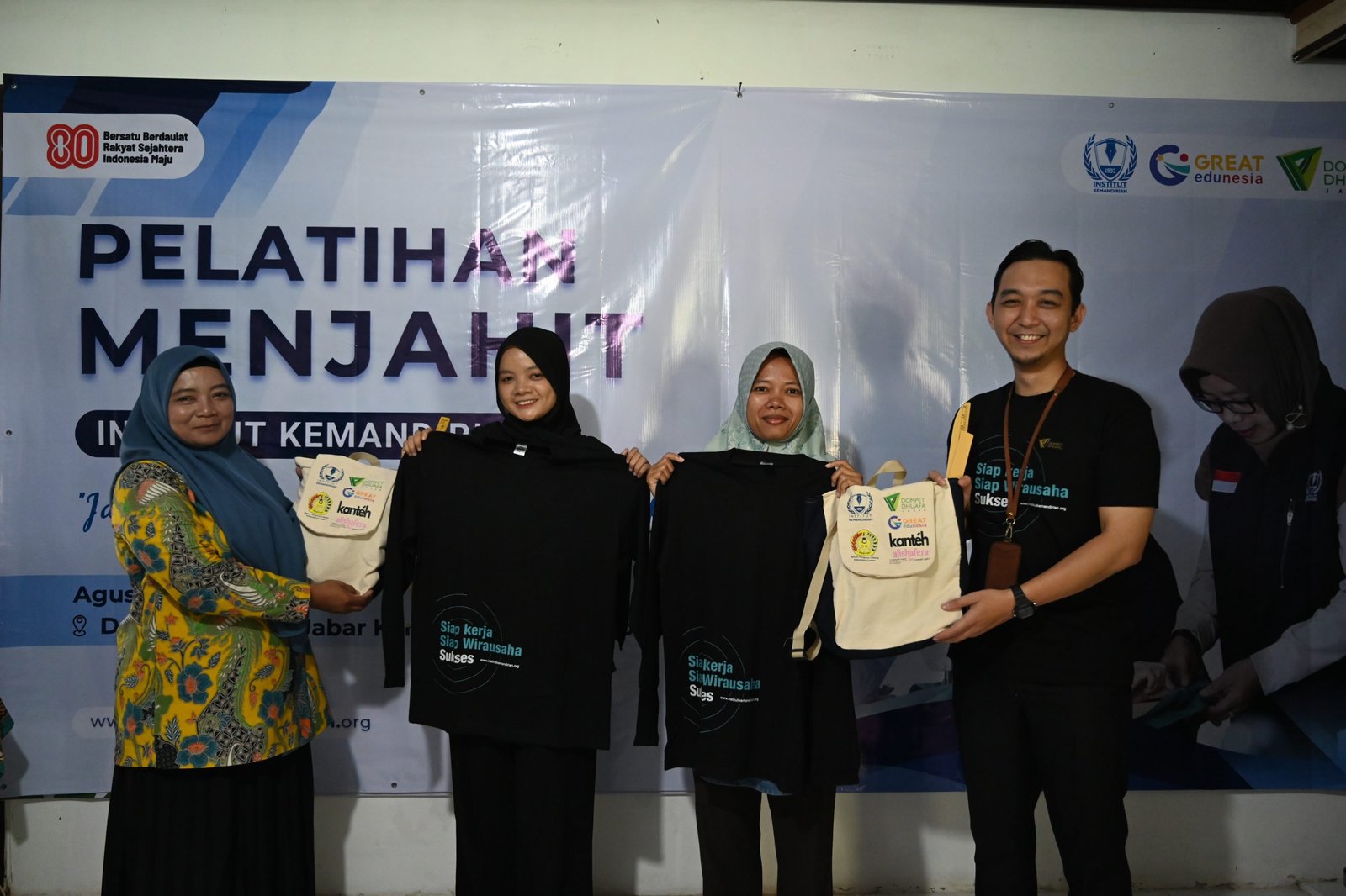 Simbolis penyerahan kaos sebagai penanda dimulainya pelatihan oleh Pimpinan Cabang Dompet Dhuafa Jawa Barat, Yogi Achmad Fajar dan Instruktur pelatihan, Sri Agustina Darajat kepada perwakilan peserta pelatihan menjahit, Cirebon, 21 Agustus 2025