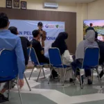 Instruktur Setiawan Chogah memberikan materi literasi finansial Merawat Kebun Rezeki kepada peserta pelatihan Barber, Menjahit, dan Bright Migrant Worker di ruang kelas Institut Kemandirian, Karawaci, Tangerang, dengan presentasi ilustrasi kebun rezeki ditampilkan di layar.