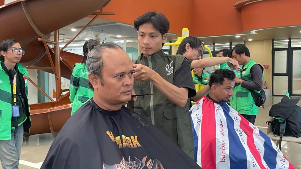Alumni IK dari Paradaya Movement mencukur driver ojol tuli