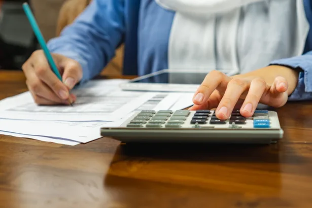 Close,Up,Of,Muslim,Woman,Using,Calculator,And,Tablet,Doing